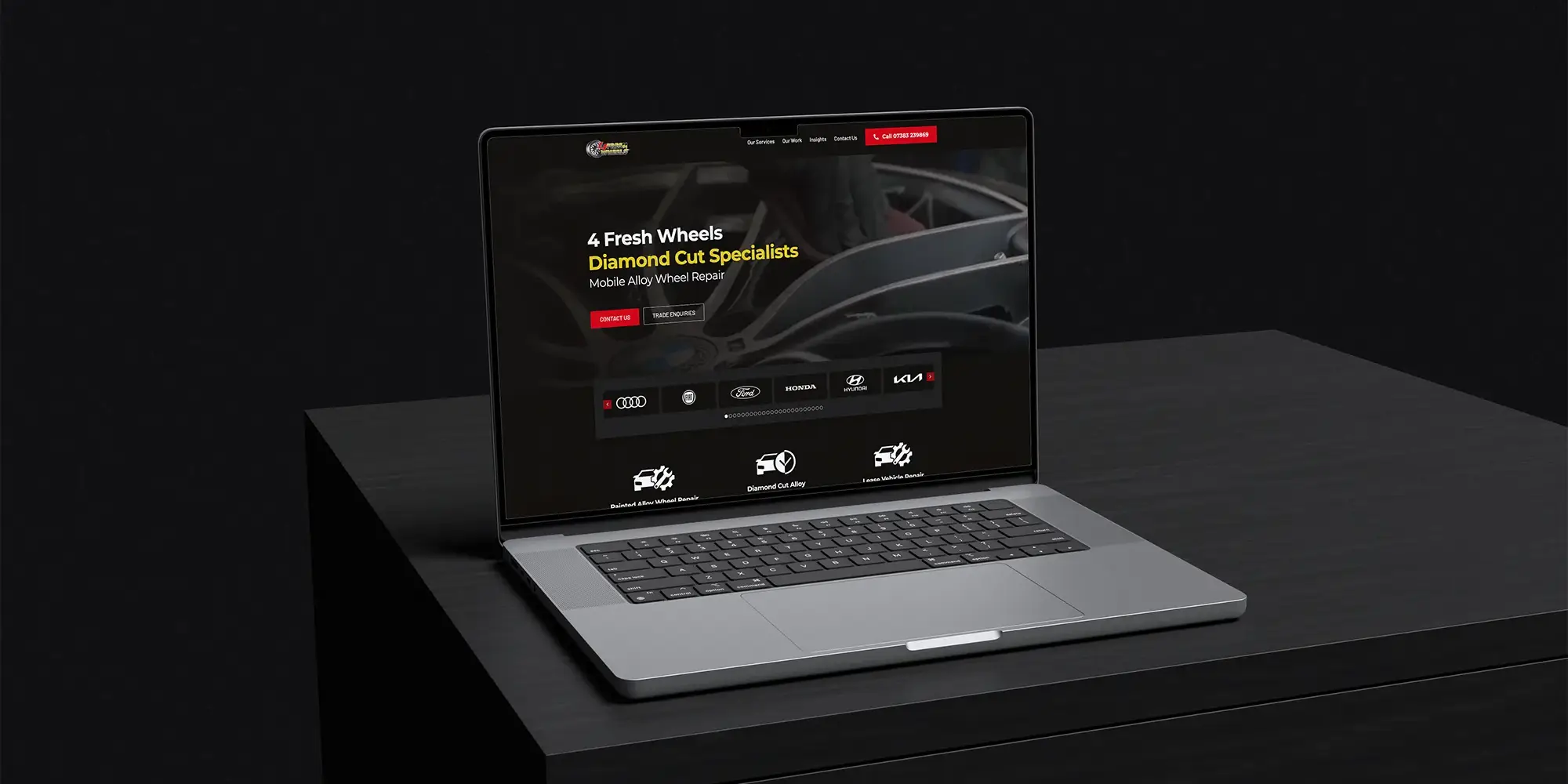 Image shows the 4 Fresh Wheels website displayed on a laptop on a cupboard in a dark room